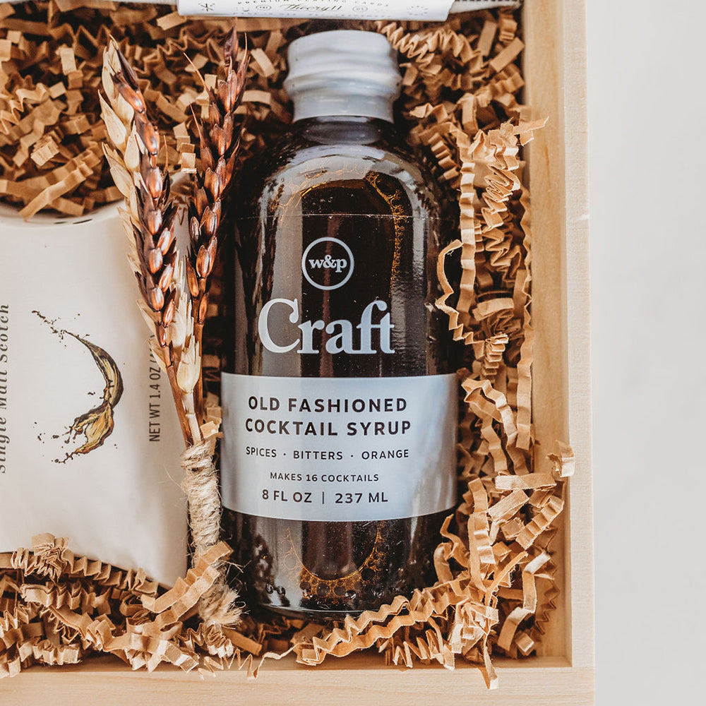 All the ingredients for a sophisticated nightcap. This gift box combines gourmet treats, specialty cocktail inspired contents, and a splash of fun for a refined night ahead. Close up of Old Fashioned Craft Cocktail Mixer Syrup