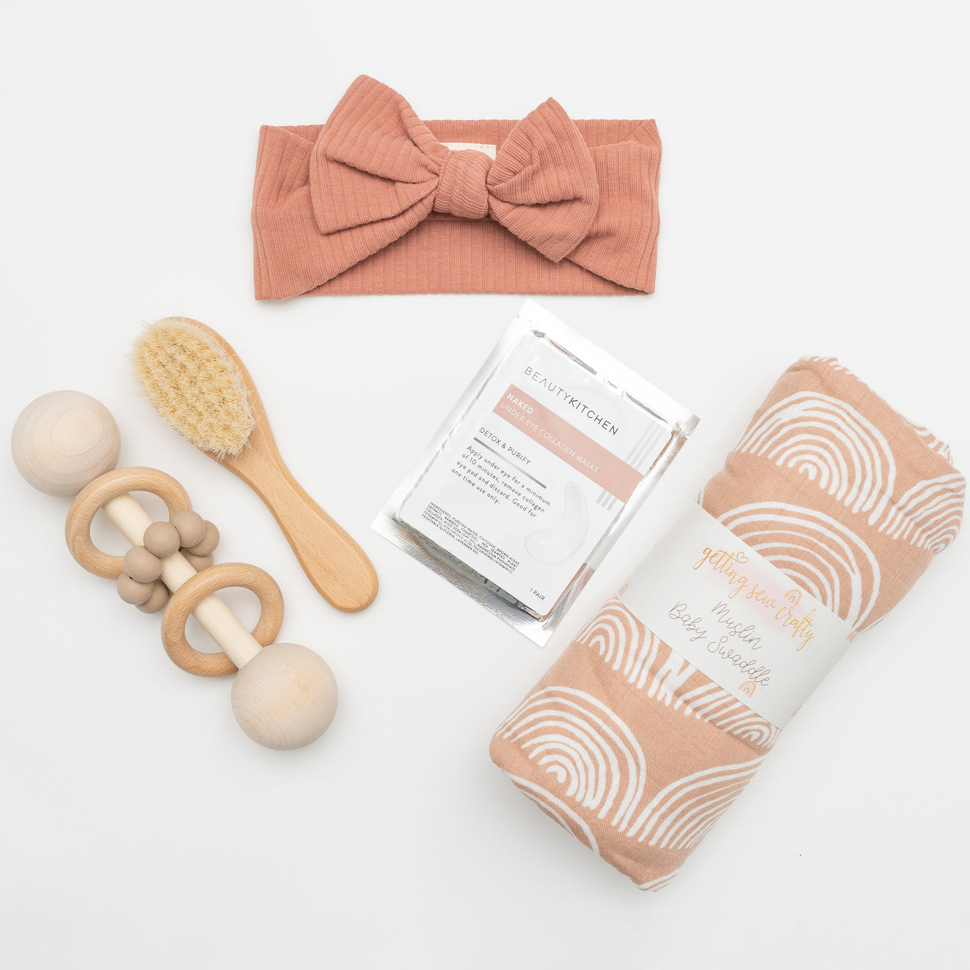 Celebrate the arrival of a new baby with this modern, elegant and practical gift box. Items: Swaddle Blanket, Organic Cotton Headband, Natural Wood Rattle, Naked Collagen Eye Gels, Soft Baby Hair Brush.