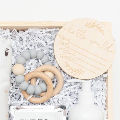 Celebrate the milestone of a new baby (and mom!) in your life with this thoughtful and elegant gift box. Close up of Teething ring and Birth Announcement Wood Disc