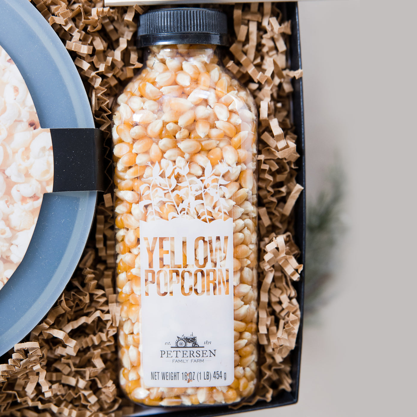 A clever and playful gift to help foster connection at home. This gift box includes all the makings of an amazing game night! Close up of Farm Fresh Yellow Bottled Popcorn
