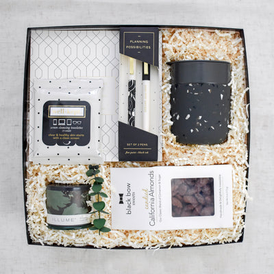 Celebrate the professional milestones and encourage perseverance for all things that lie ahead. This large 2 pc black gift box contains: Daily Planner Pad, Pen Set, Ceramic Mug, Screen Cleansing Towelettes, Blackberry Absinthe Candle, and California Candied Almonds.